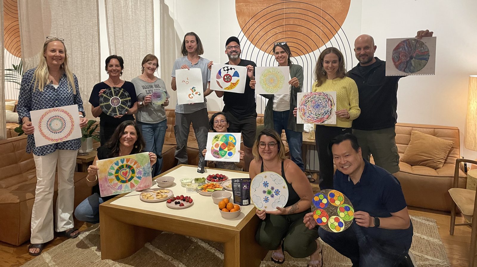 A group holding up their hand-painted mandala artwork together